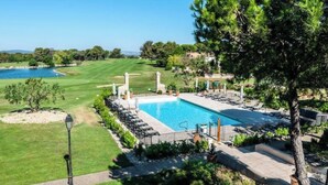 Ein Poolbereich mit Blick auf einen Golfplatz und einen See.