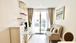 Un salon moderne avec un canapé, un meuble blanc et un tableau accroché au mur.
