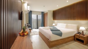 Una habitación de hotel moderna con una cama de madera, una mesita de noche y un frutero.