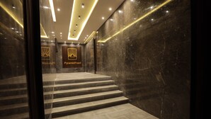 Una escalera de mármol conduce a un vestíbulo con señalización iluminada que dice 'Pyramid Front'.