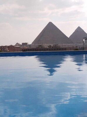 Une piscine offrant une vue sur deux pyramides en arrière-plan.