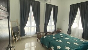A bedroom with a bed, a ceiling fan, and a window with curtains.