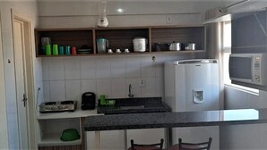 A compact kitchen with a microwave, coffee maker, and a small sink. - Lacqua DiRoma IV - Gran Caldas Reservas (Caldas Novas)