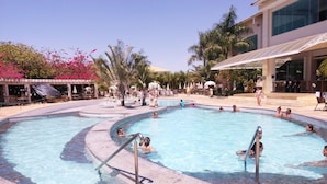 A pool area with multiple swimming pools, lounge chairs, and palm trees. - Lacqua DiRoma IV - Gran Caldas Reservas (Caldas Novas)