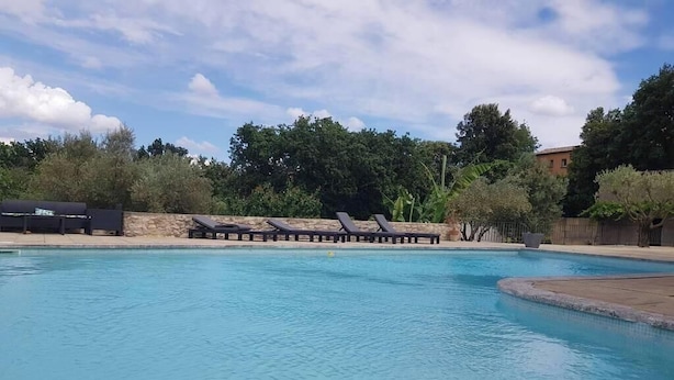 Ein Schwimmbecken mit Liegestühlen und einer Steinmauer.