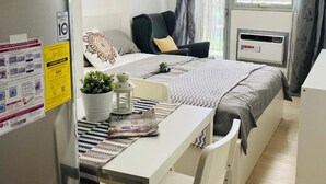 Ein modernes, kleines Schlafzimmer mit Bett, Nachttisch und einer kleinen Schreibtischzeile.