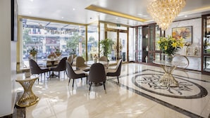 A modern dining area with a chandelier, a marble floor, and a view of the street outside. - Diamond Luxury Hotel (Hong Gai)