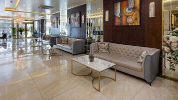 Un moderno vestíbulo con una mesa de centro de mármol, sofás y una araña.