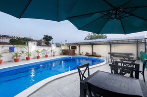 Una piscina al aire libre, sombrillas