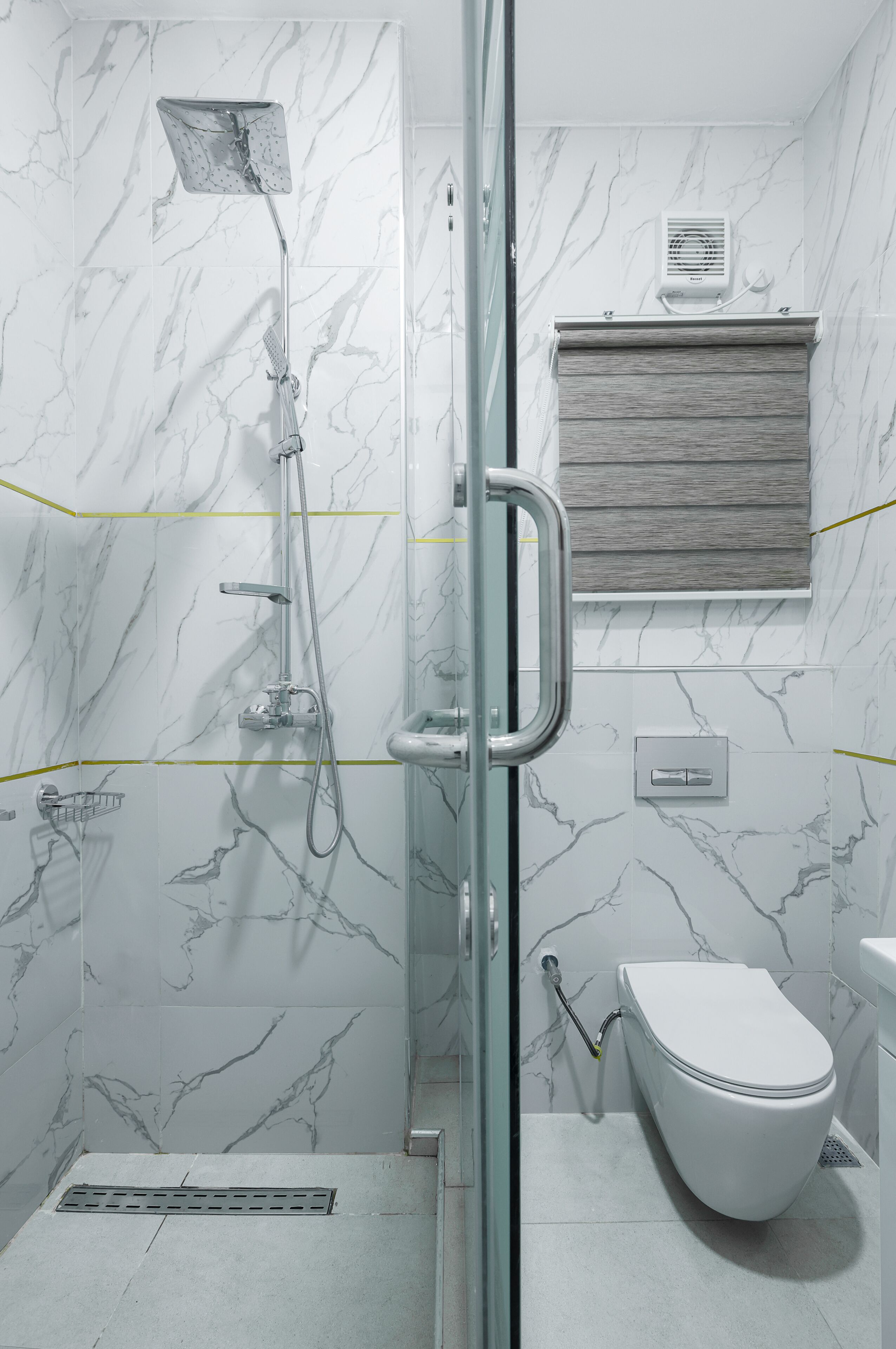 A modern bathroom with a glass shower enclosure, a toilet, and a vanity with a mirror.