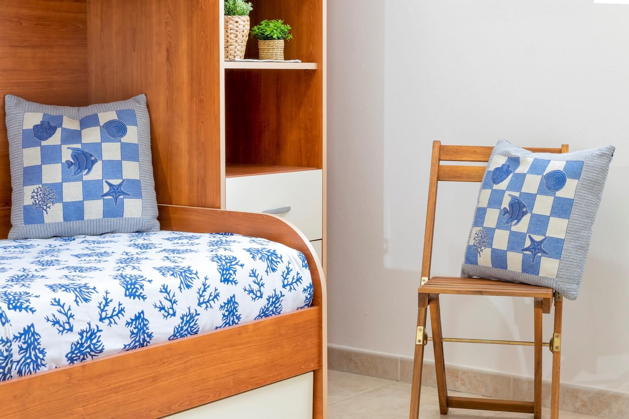 Un dormitorio con una cama de madera, una silla a juego y una estantería con una planta.