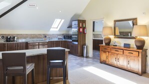 Une cuisine moderne dotée d’un îlot central, de meubles en bois et d’une verrière.