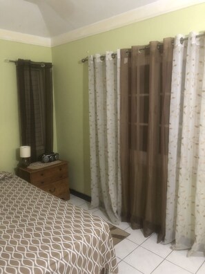 A bedroom with a bed, a dresser, and curtains. - Finest Accommodation Renfrew Place  (Kingston)