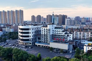 Stadsbeeld met moderne gebouwen, een parkeerplaats en een heldere lucht.