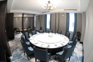 A conference room with a round table, chairs, and a chandelier. - Yanshi Hotel (Luoyang)
