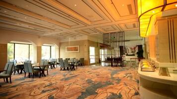 A spacious lobby with a patterned carpet, a reception desk, and multiple seating areas.