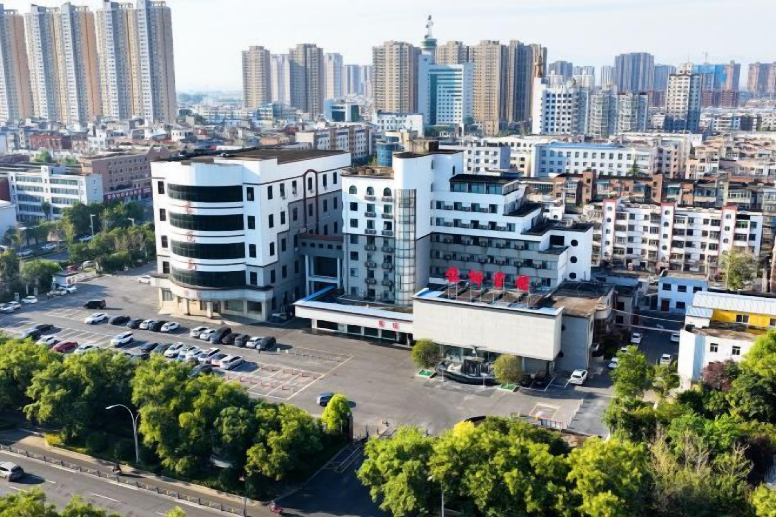 A multi-story building with a parking lot in front.