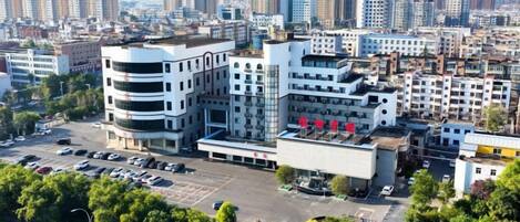 A multi-story building with a parking lot in front.