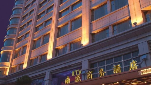 Un edificio de hotel de varios pisos con señalización iluminada.