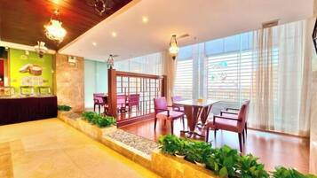 A hotel lobby with a reception desk, seating area, and large windows.