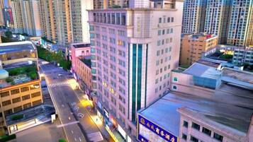 A high-rise building with multiple floors, a central courtyard, and a street in front.