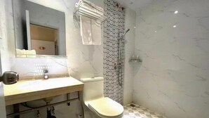 A bathroom with a toilet, sink, mirror, and shower. - Zhicheng Youpin Hotel (Yingbin Avenue) (Jiangmen)