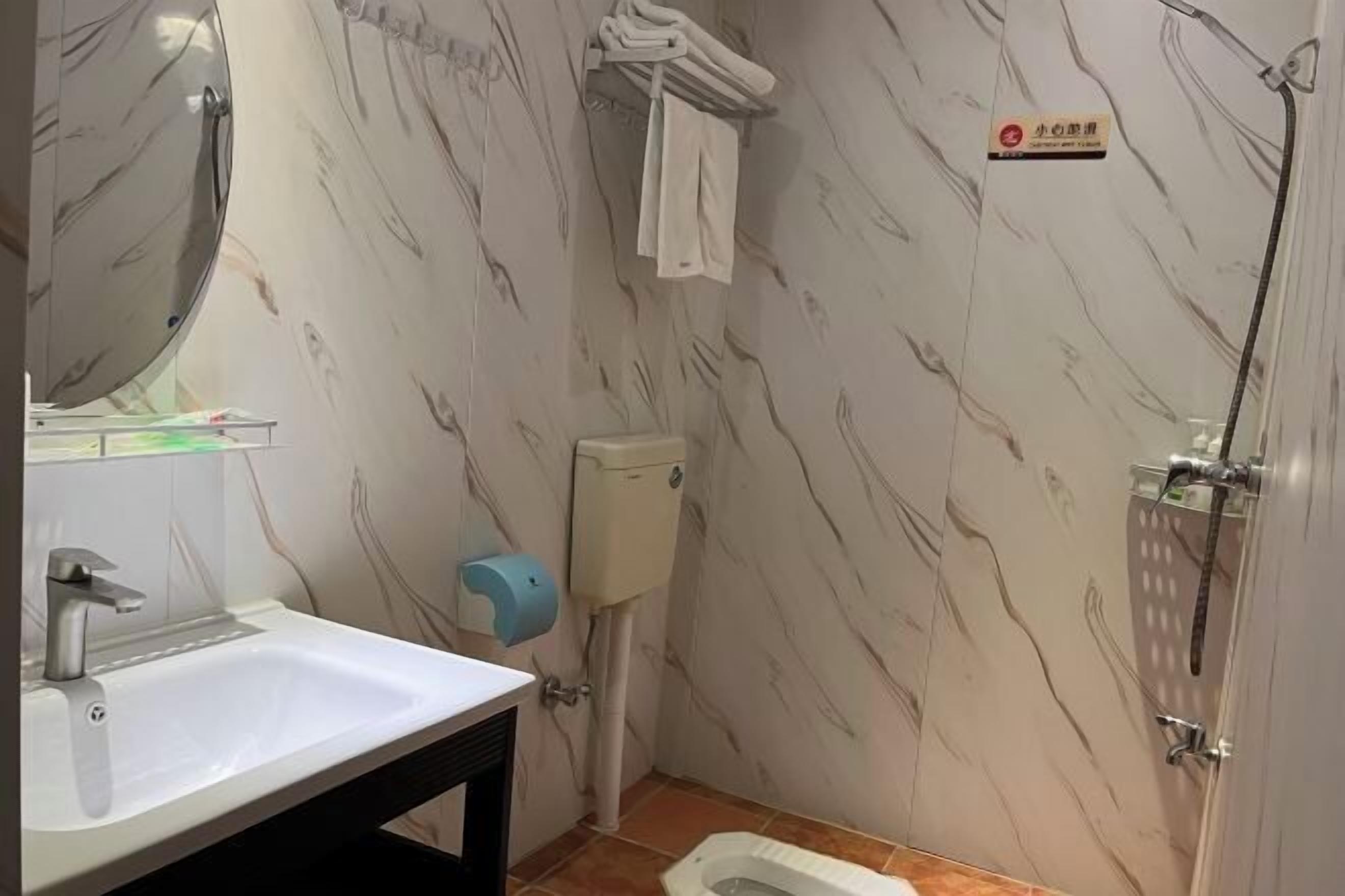 A bathroom with a sink, toilet, and shower.
