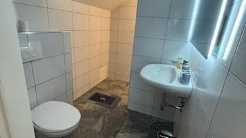 Un baño pequeño con inodoro, lavamanos y espejo.