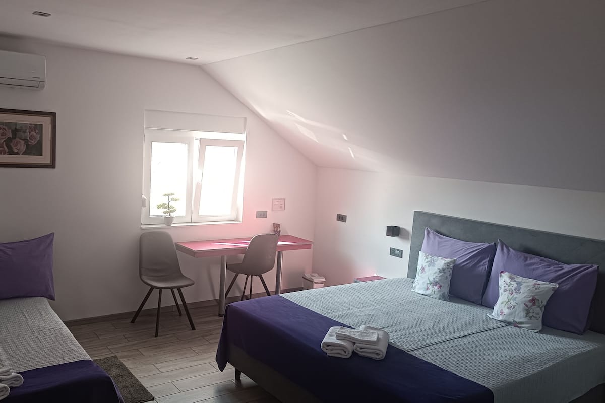 Un dormitorio con dos camas, un escritorio y una silla.
