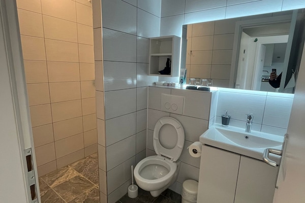 Economy kamer | Badkamer | Een douche, een haardroger, handdoeken
