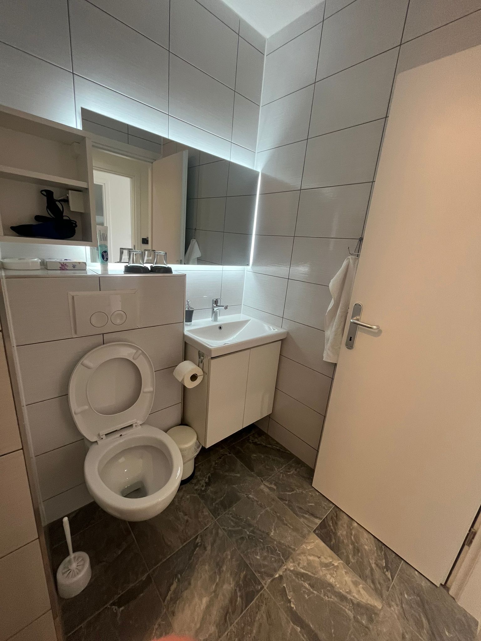 Un baño pequeño con inodoro, lavabo y espejo.