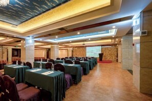 A conference room with rows of tables and chairs, a podium, and a large screen. - Hengda Hotel (High-speed Railway Station Branch) (Tongren)
