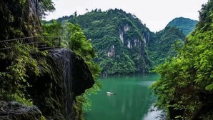 A narrow waterway flanked by steep, forested cliffs with a small boat in the center. - Hengda Hotel (High-speed Railway Station Branch) (Tongren)