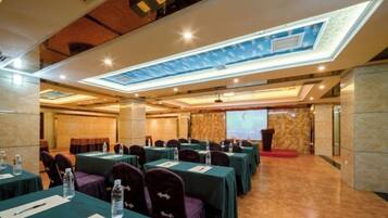 A conference room with tables, chairs, and a presentation screen.