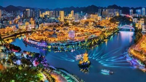 A cityscape with a river, traditional architecture, and modern buildings. - Hengda Hotel (High-speed Railway Station Branch) (Tongren)
