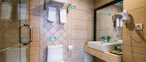 A modern bathroom with a glass shower enclosure, a toilet, a sink with a mirror, and a towel rack.