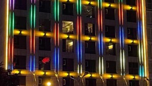 Un edificio de varios pisos con franjas verticales de luz y ventanas iluminadas.
