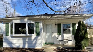 A small, single-story house with a front porch, a small garden, and a tree. - Leesburg Hideaway- King Bed + Private Backyard (Leesburg)