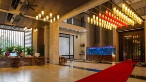 A spacious lobby with a red carpet, a reception desk, and a large aquarium. - Shile Hotel (Zhongshan Station) (Zhongshan)