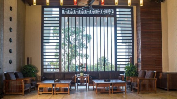 A spacious room with a large window, wooden furniture, and a ceiling fan. - Shile Hotel (Zhongshan Station) (Zhongshan)