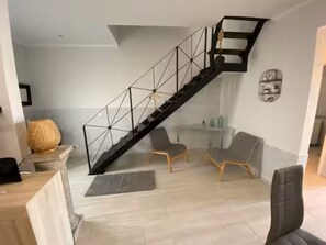 A modern living room with a staircase, a sofa set, and a coffee table.