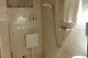 Ein Badezimmer mit Dusche, Toilette und Waschbecken.