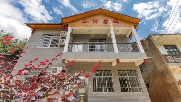 Un edificio de dos pisos con fachada de madera y balcón.