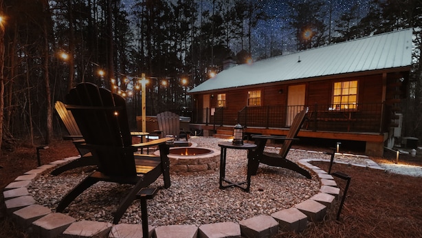 A cabin with a fire pit, outdoor seating, and a deck.