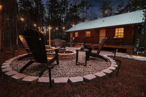 A cabin with a fire pit, outdoor seating, and a deck.