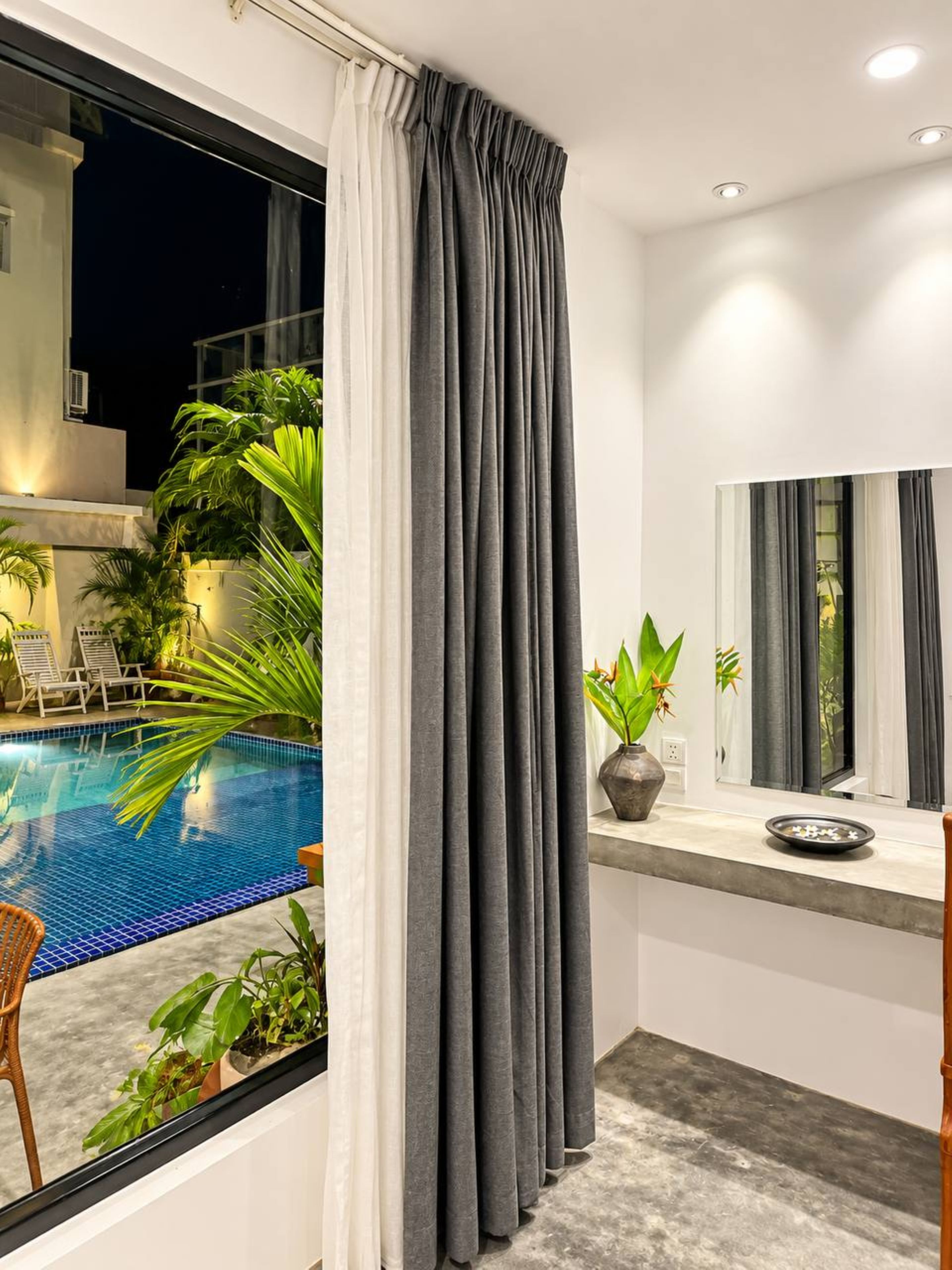 A modern bathroom with a large window, a pool, and a mirror.