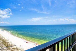 A beach with clear turquoise water, a sandy shore, and a view of the ocean. - The Oasis 2311 | Spacious, Lazy River, Poolside Grill, New Splash Pad, Pool with Slide! (Orange Beach)