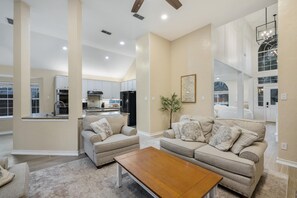 Relax in a spacious living area with a large coffee table and two sofas, complemented by a well-equipped kitchen.