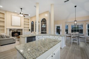 Enjoy a warm and inviting kitchen with a central island, cozy seating area, and fireplace.