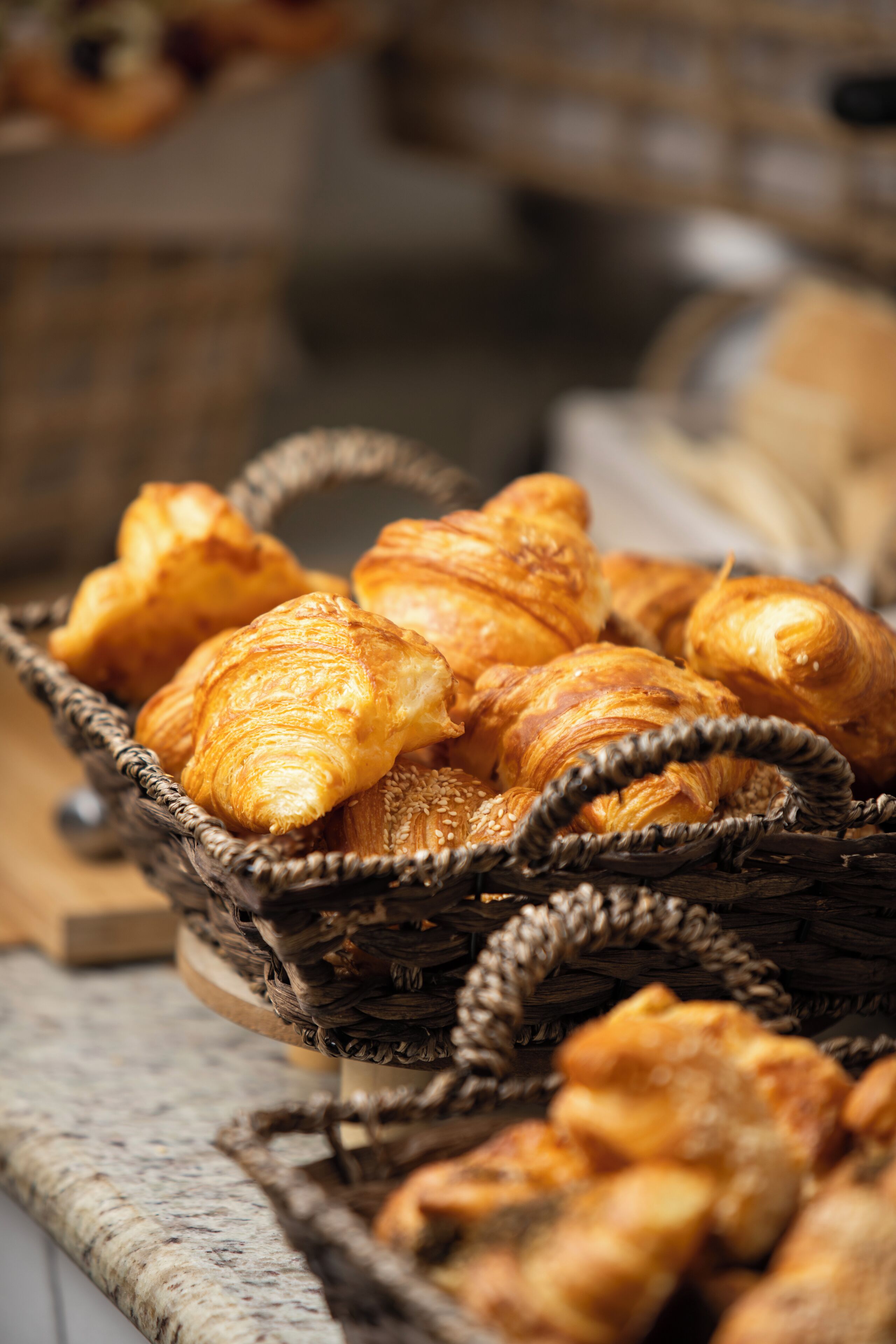 A basket of croissants on a countertop.